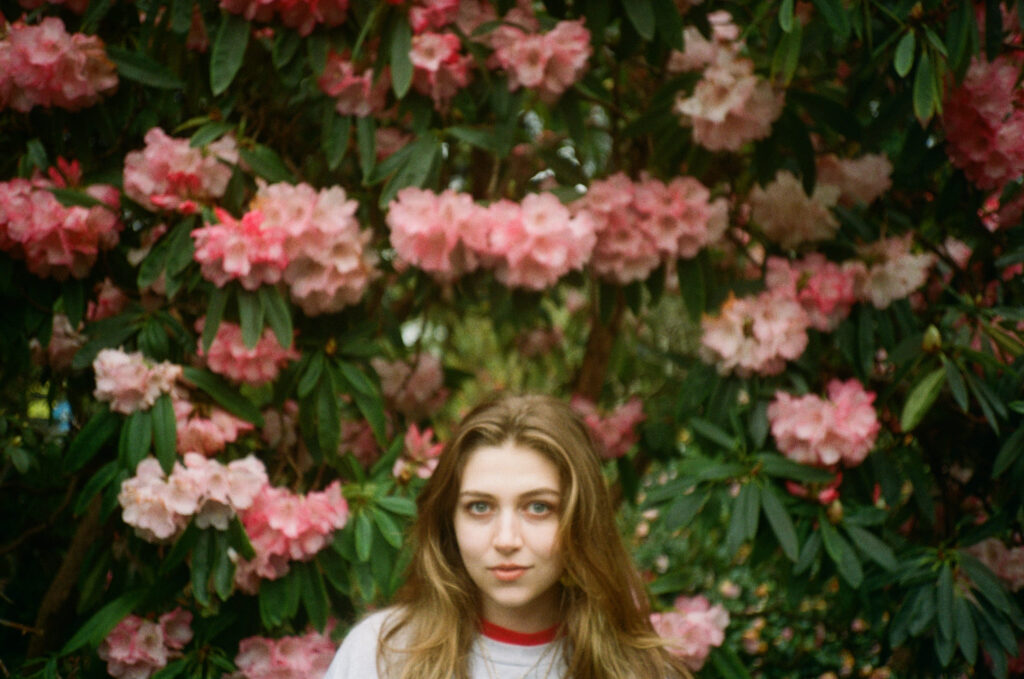 Woman portrait among pink rhododendron blossoms